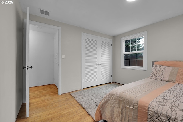 bedroom with light hardwood / wood-style floors and a closet