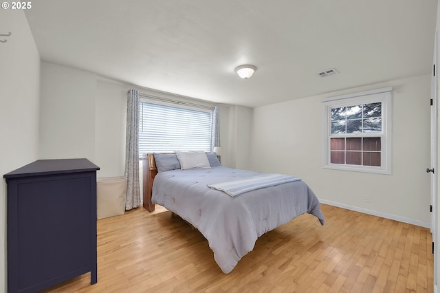 bedroom featuring multiple windows and light hardwood / wood-style floors