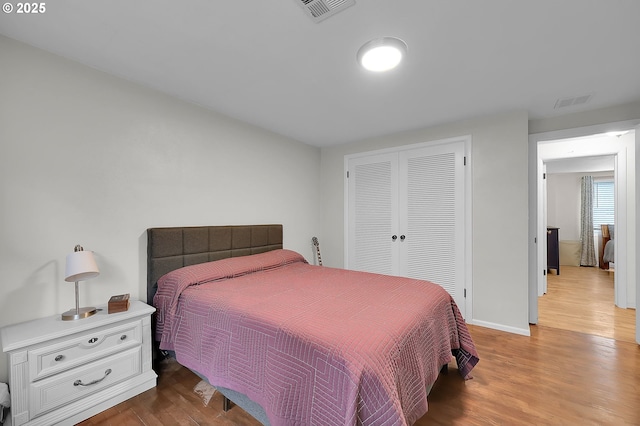 bedroom with light wood-type flooring and a closet