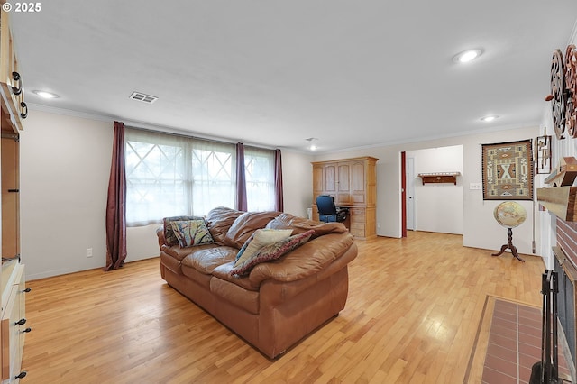 living room featuring crown molding, a barn door, and light hardwood / wood-style floors