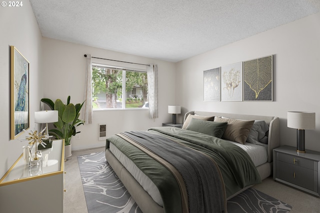 bedroom featuring a textured ceiling and light colored carpet