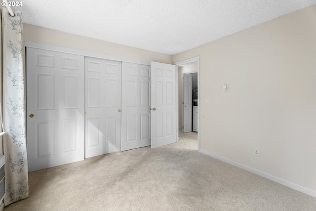 unfurnished bedroom with a closet, light carpet, and a textured ceiling