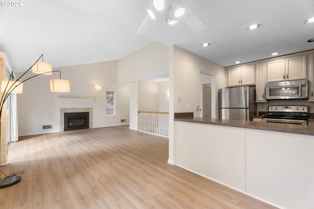 kitchen featuring appliances with stainless steel finishes, a textured ceiling, light hardwood / wood-style floors, and ceiling fan