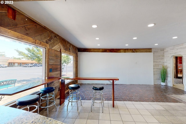 game room featuring light tile floors and wooden walls