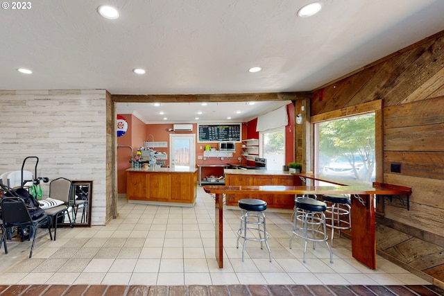 interior space featuring wood walls, ornamental molding, and light tile floors