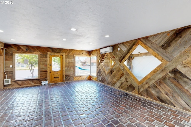 entryway with wood walls and a wall mounted AC