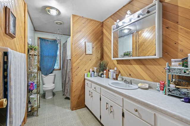 bathroom featuring wood walls, vanity, and toilet