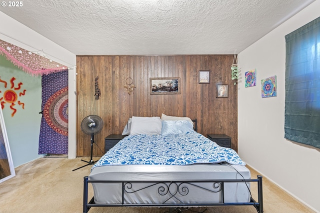 bedroom with wooden walls, a textured ceiling, and light carpet