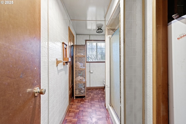 bathroom with water heater, tile walls, and parquet flooring