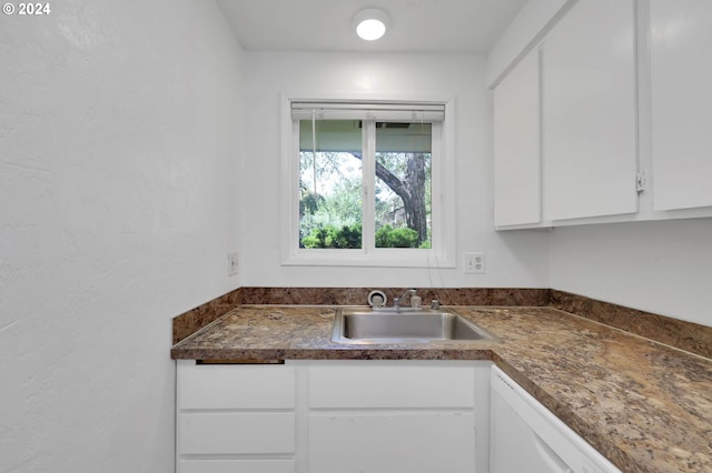 kitchen featuring white cabinets, dishwasher, and sink