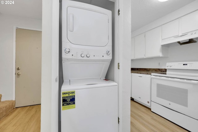 laundry area featuring stacked washer / dryer and light hardwood / wood-style flooring