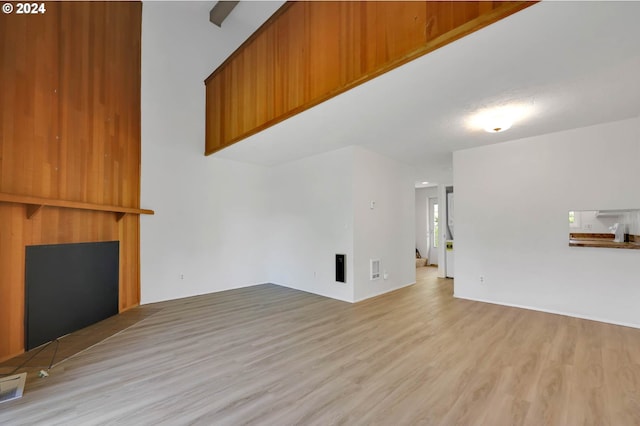 unfurnished living room with a large fireplace and light hardwood / wood-style floors