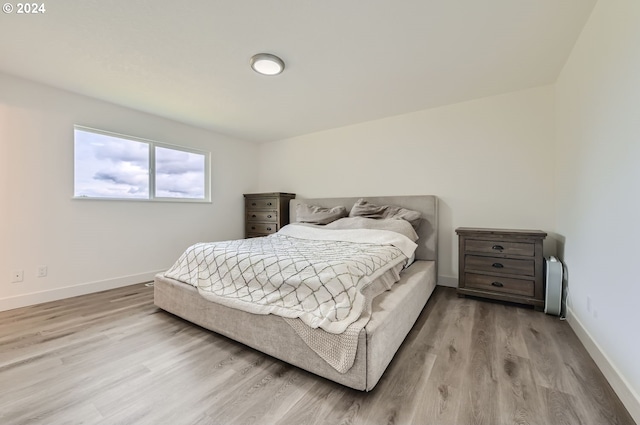 bedroom featuring light wood-style floors and baseboards