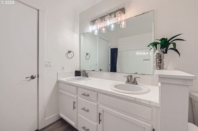 bathroom with double vanity, curtained shower, and a sink