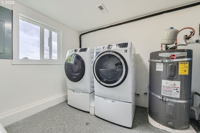 clothes washing area featuring laundry area, visible vents, baseboards, strapped water heater, and separate washer and dryer