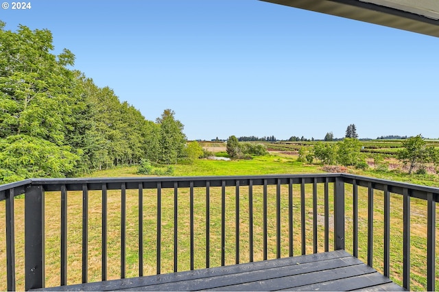 deck featuring a rural view and a yard