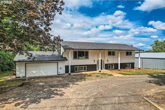 bi-level home with concrete driveway, fence, and an attached garage