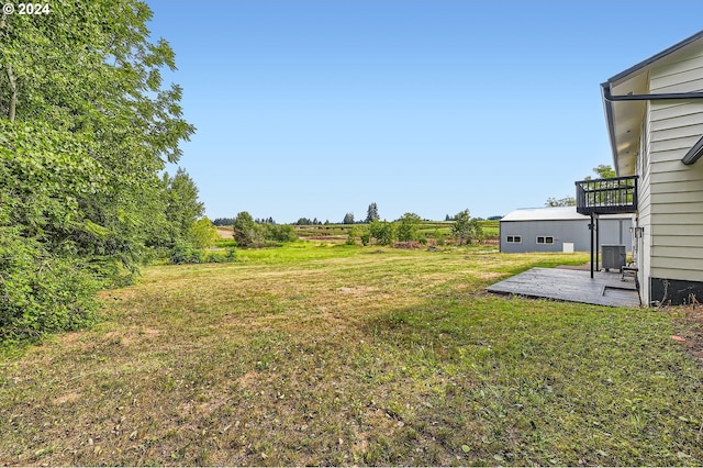 view of yard featuring a balcony and central AC unit