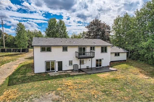 back of property with a patio area, a lawn, a balcony, and central air condition unit