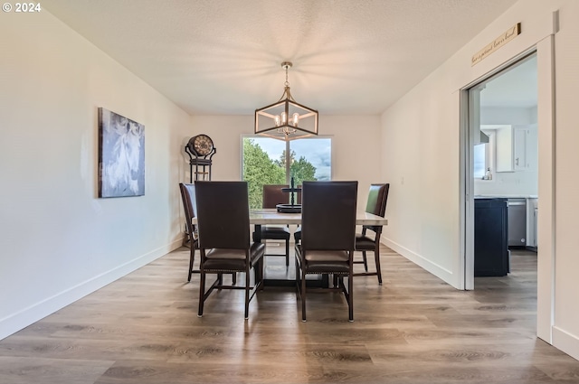 dining area with an inviting chandelier, baseboards, and wood finished floors