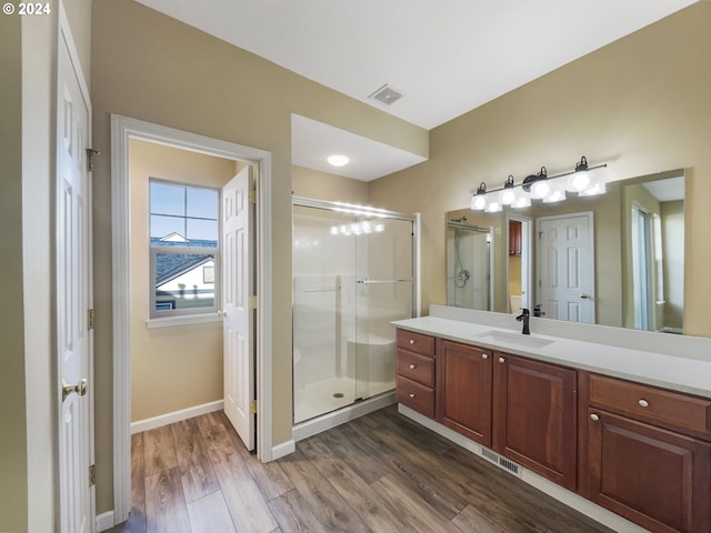 bathroom with vanity, hardwood / wood-style flooring, and a shower with door