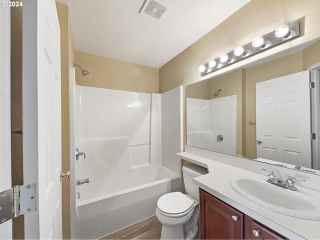 full bathroom with hardwood / wood-style flooring, vanity, toilet, and shower / tub combination