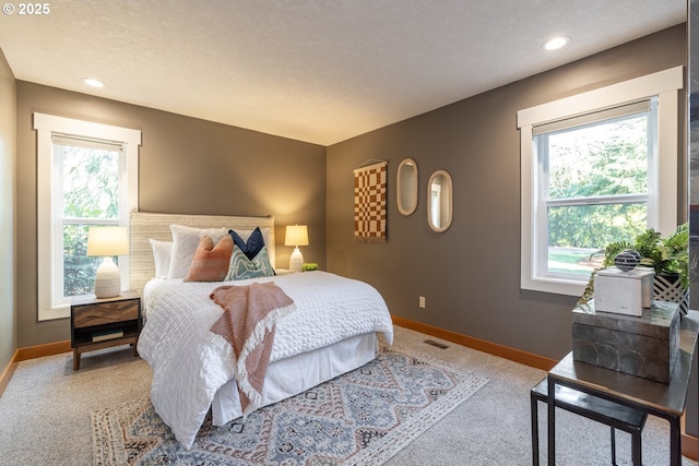 bedroom featuring light carpet and a textured ceiling