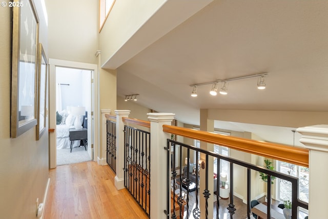 hall featuring lofted ceiling and light hardwood / wood-style flooring