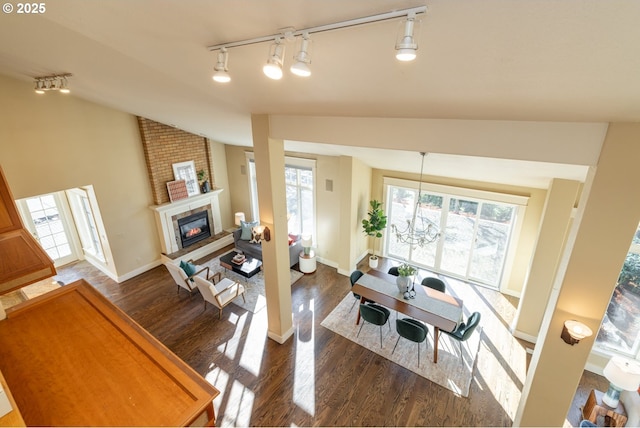 living room featuring dark wood-type flooring, vaulted ceiling, and a healthy amount of sunlight