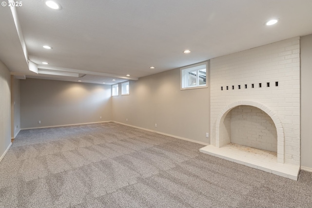 basement featuring light carpet and a fireplace