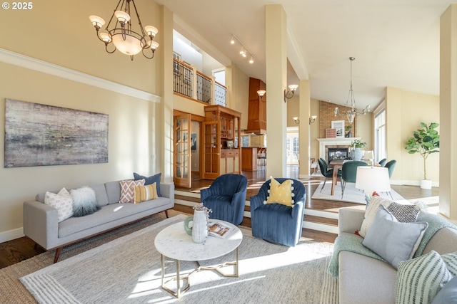 living room featuring high vaulted ceiling, a chandelier, and light hardwood / wood-style flooring