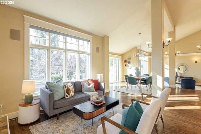 living room with wood-type flooring, a notable chandelier, and high vaulted ceiling