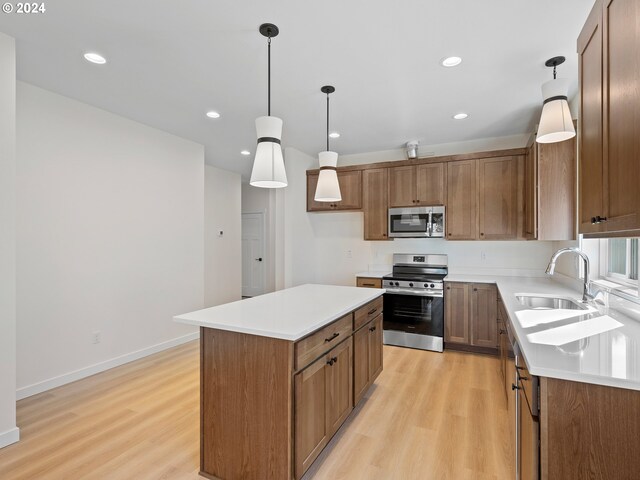 kitchen with a raised ceiling, a center island, light wood-type flooring, and hanging light fixtures