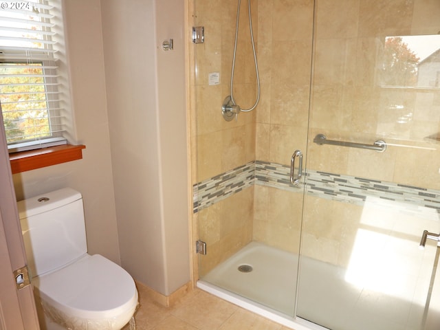 bathroom with tile patterned floors, toilet, and an enclosed shower