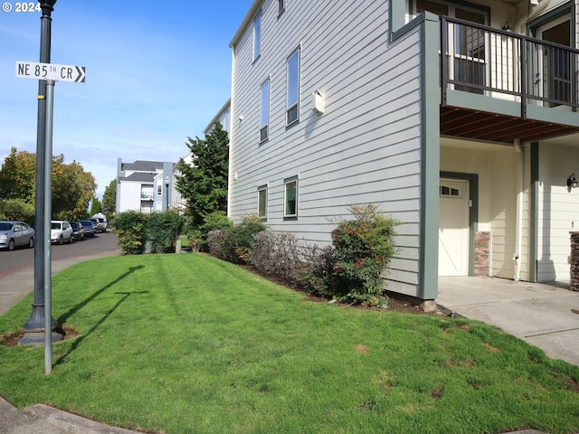 view of home's exterior with a yard and a balcony