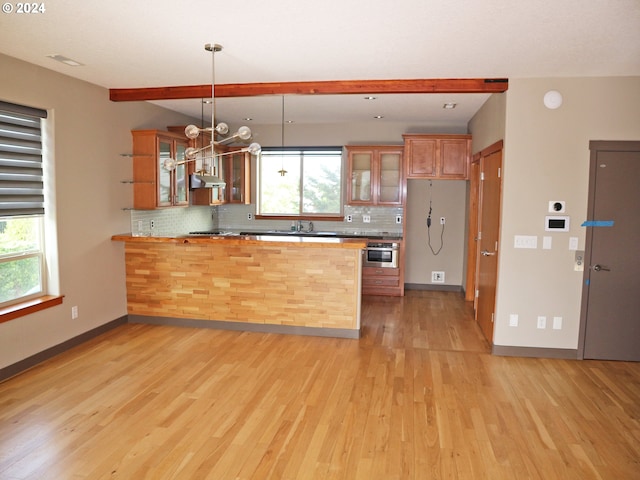 kitchen featuring light hardwood / wood-style floors, kitchen peninsula, and plenty of natural light