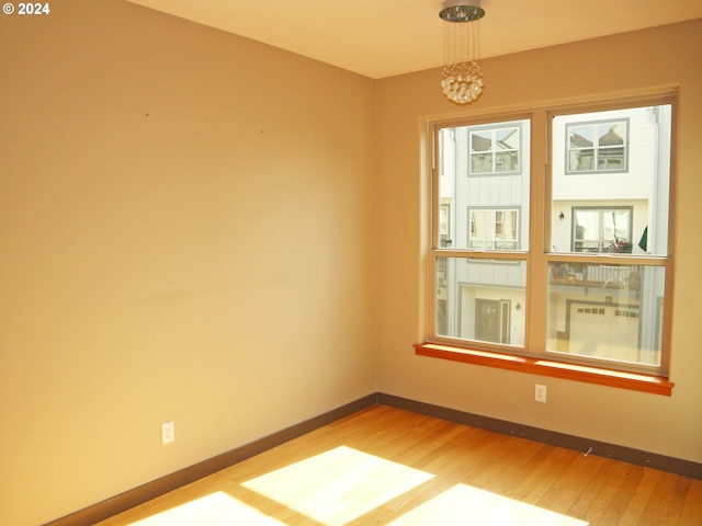 empty room featuring hardwood / wood-style floors and a chandelier