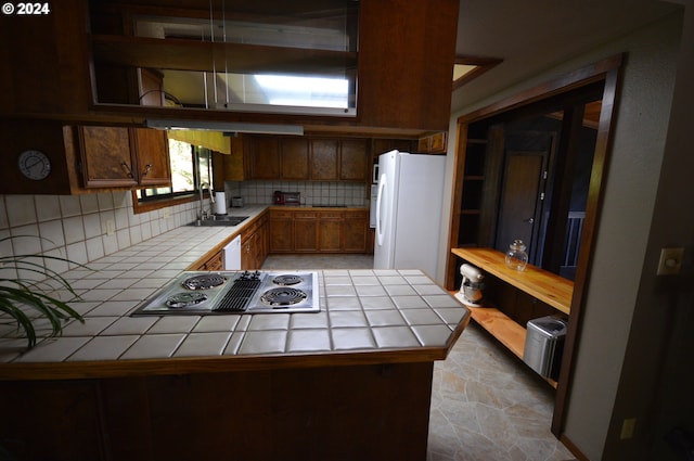 kitchen featuring tile counters, decorative backsplash, white appliances, and sink