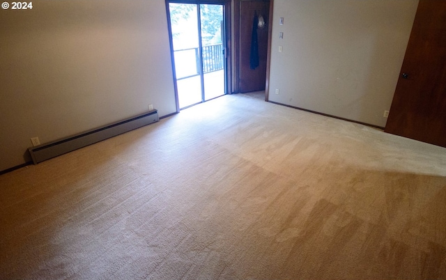 carpeted empty room with a baseboard radiator