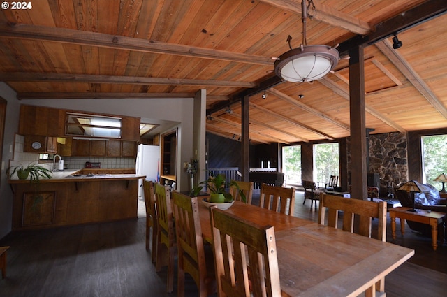 dining room with vaulted ceiling with beams, dark wood-type flooring, and wood ceiling