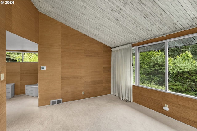 unfurnished room with wood ceiling, vaulted ceiling, carpet floors, and wooden walls