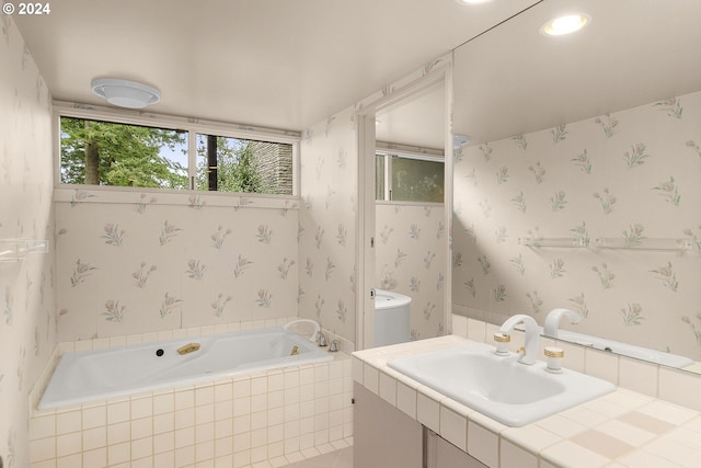 bathroom featuring tiled bath and vanity