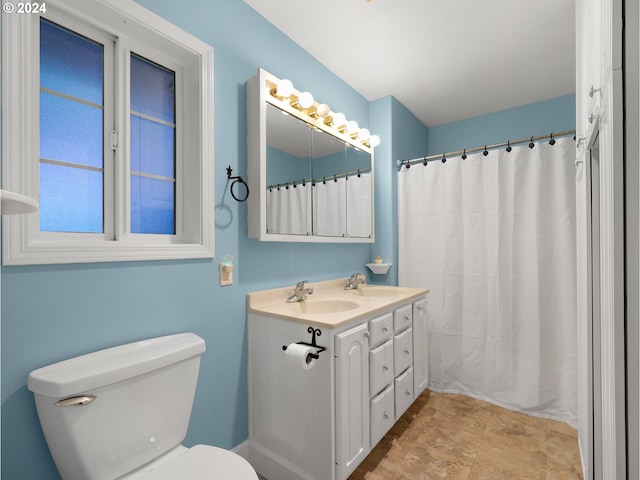 bathroom featuring curtained shower, vanity, and toilet