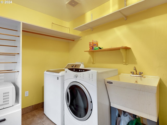 laundry area with light tile patterned flooring, sink, and washing machine and clothes dryer