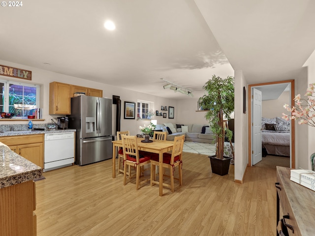 kitchen with stainless steel refrigerator with ice dispenser, track lighting, white dishwasher, and light hardwood / wood-style flooring