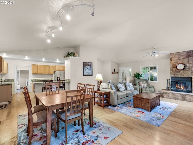 dining area with ceiling fan, a fireplace, and light hardwood / wood-style flooring