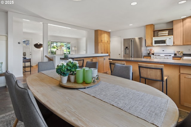 dining room featuring baseboards, dark wood finished floors, and recessed lighting