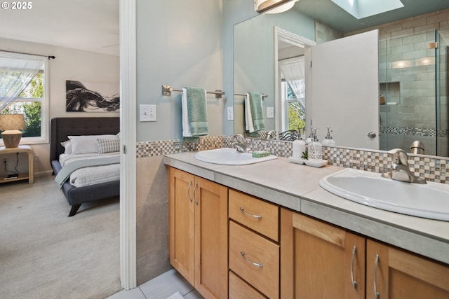 full bathroom with a skylight, a sink, a shower stall, and double vanity