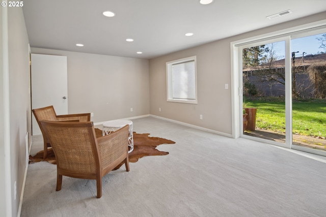 sitting room with light colored carpet, recessed lighting, visible vents, and baseboards