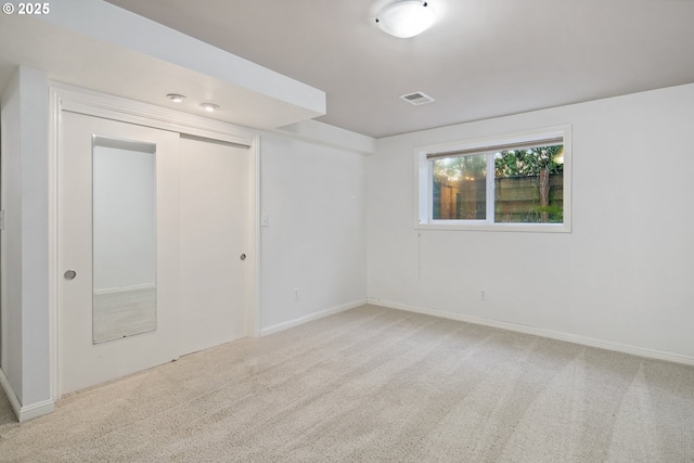 carpeted empty room featuring visible vents and baseboards